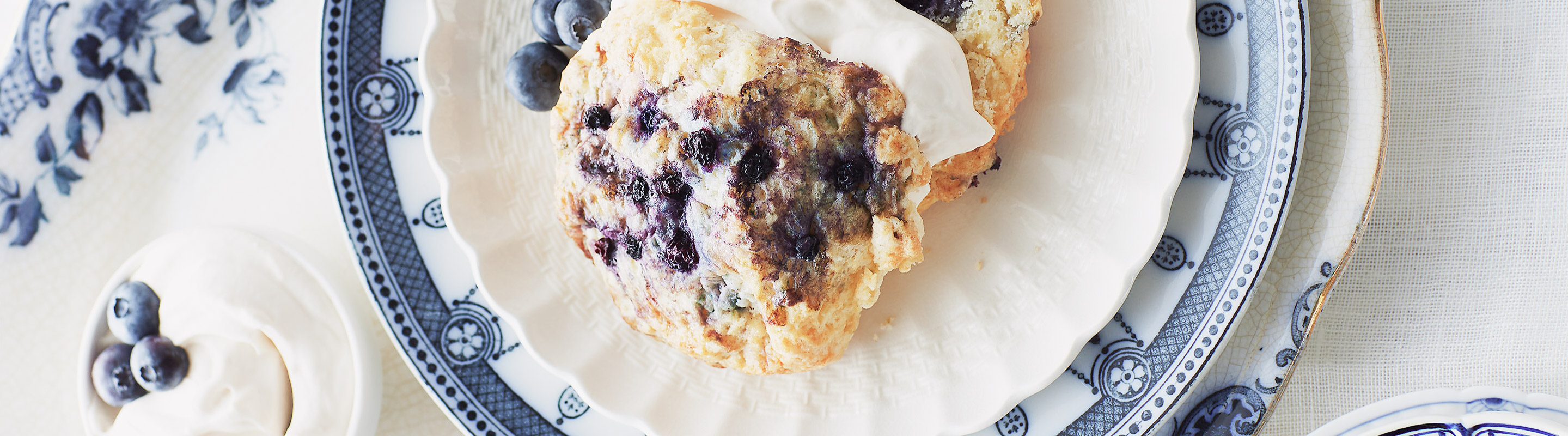 A selection of breakfast pastries from Bobbette & Belle, including blueberry scones with Devonshire cream and lemon curd, and a variety of croissants.