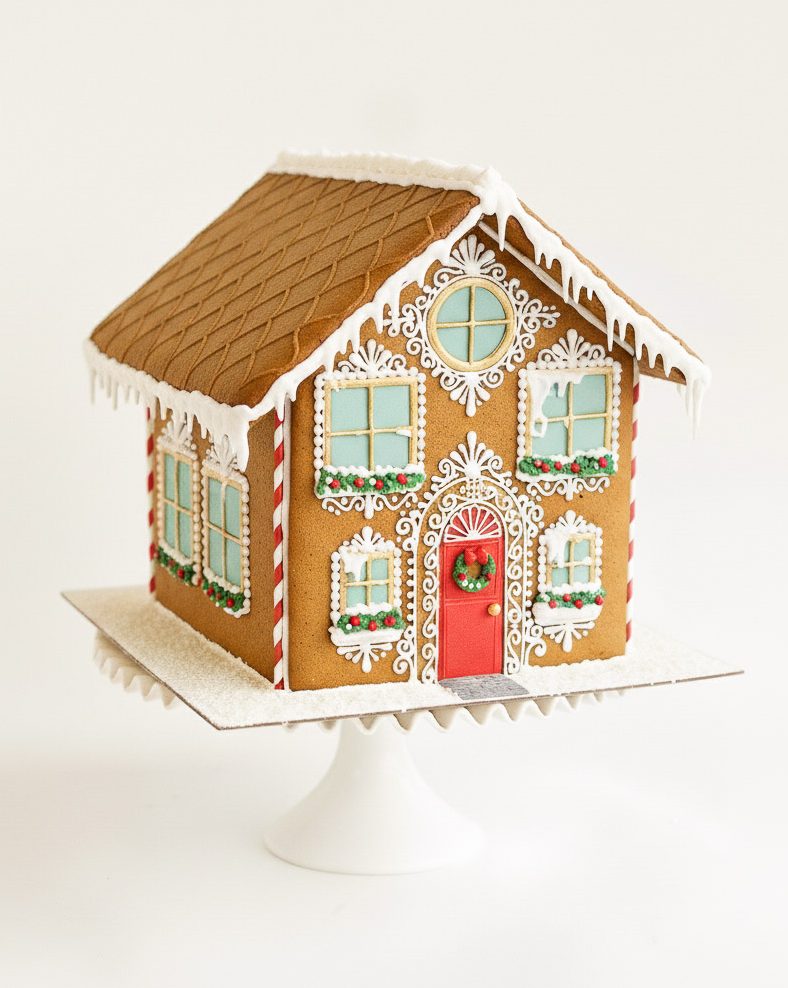 Traditional Christmas Gingerbread House 4 Elaborately decorated gingerbread house with red door, candy canes, and white royal icing